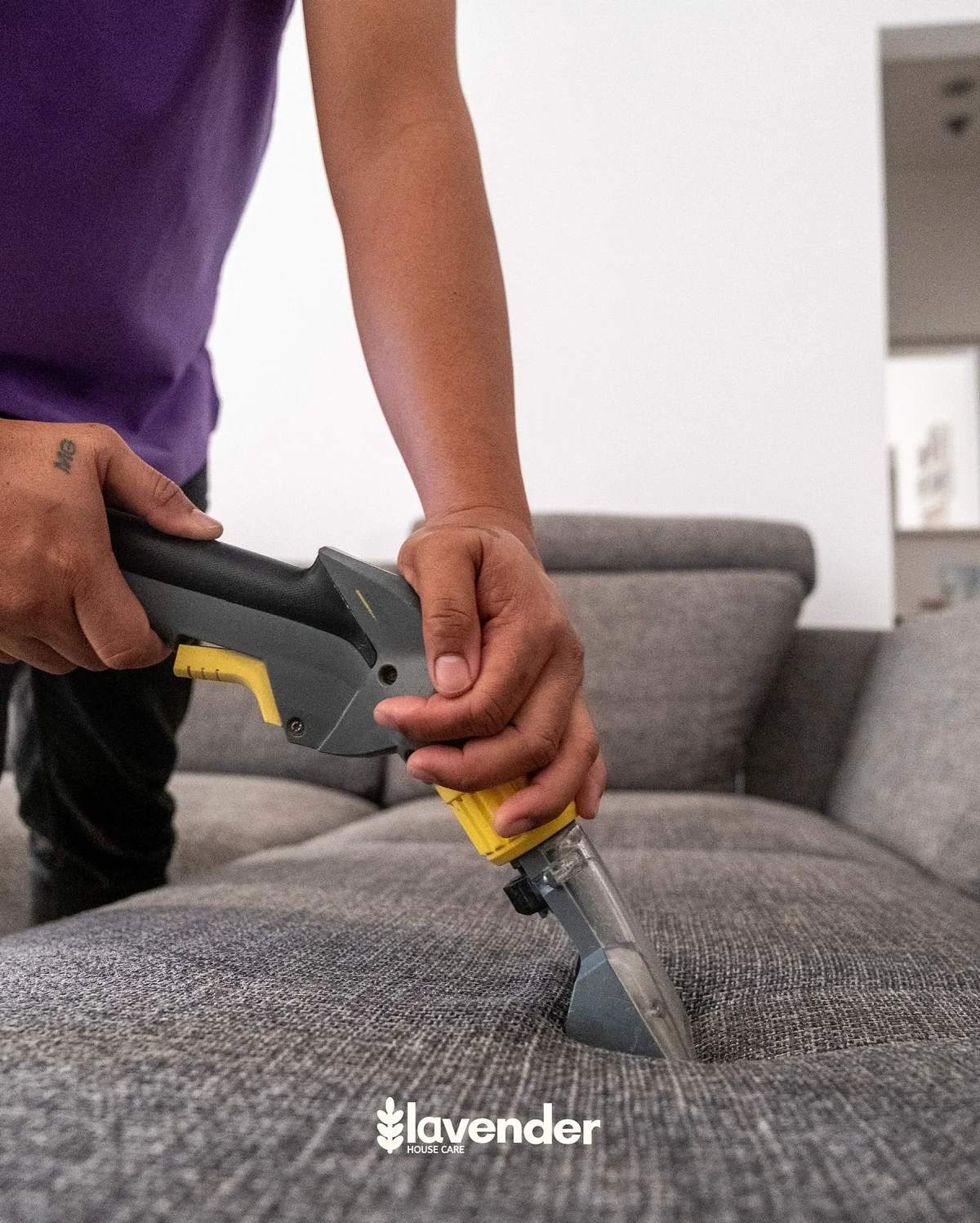 Professional sofa clean from Lavender Housecare in Dubai. Cleaner is using a Karcher upholstery machine and making sure all bacteria and dust is removed from the sofa.